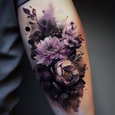 a woman's arm with flowers on it and watercolor paint splatters