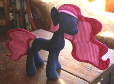 a stuffed pony sitting on top of a wooden table