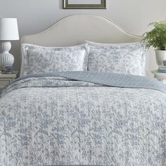 an image of a bedroom setting with blue and white bedding