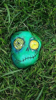 a painted rock sitting on top of green grass