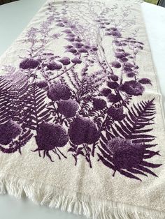 a purple and white rug with flowers on it