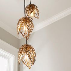 three light fixtures hanging from a ceiling in a room with white walls and flooring