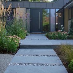 a modern house with stone steps leading to the front door