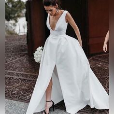 a woman in a white dress is standing on the ground