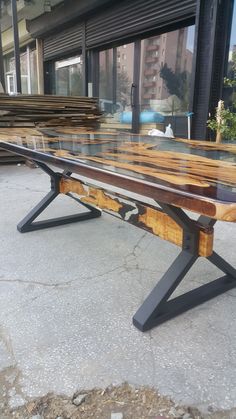 a wooden bench sitting on top of a cement ground next to a building with windows