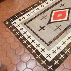 an area rug on the floor with red and brown accents