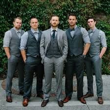 a group of men standing next to each other in front of a green planter