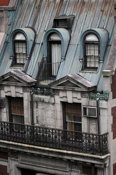 an old building with some windows and a clock on the top of it's roof