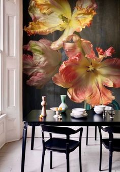 a dining room table with flowers painted on the wall