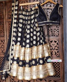 Made to Order/Measurement/Custom Order Lehenga - Color : Black - Fabric : Brocade Silk with Embroidered Border - Fully flared kalidaar lehenga with rich lining - Princess Cut Padded Sleeveless Raw Silk Blouse - Black Embellished Net Dupatta with Gold and Brocade Border - Drawstring closure with Tassels Fabric Care : Dry Clean Only Disclaimer: Please note the photographs are taken by mobile camera in sunlight The actual color of the product might slightly differ due to exposure of light or monito Fitted Black Banarasi Silk Dupatta, Traditional Fitted Black Choli, Traditional Black Dress With Pallu, Fitted Black Sharara For Festivals, Black Fitted Floor-length Traditional Wear, Black Chanderi Lehenga For Reception, Black Semi-stitched Silk Lehenga, Black Embroidered Choli Traditional Drape, Fitted Black Traditional Wear For Navratri