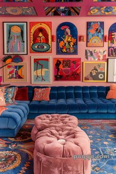 a living room filled with furniture and paintings on the wall above it's colorful couches