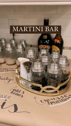 there are many jars on the counter with drinks in them, and one is labeled martini bar