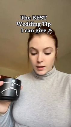 a woman holding a black cup with a skeleton drawn on it and the caption reads, the best wedding tip i can give