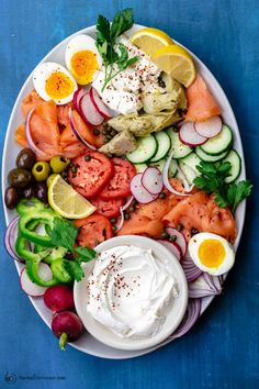 a white plate topped with lots of different types of vegetables and eggs on top of it