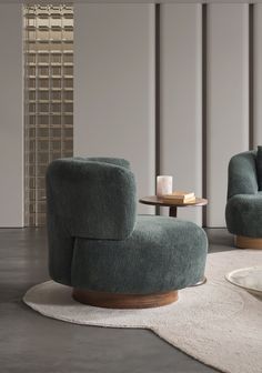 a living room with two green chairs and a white rug on the floor next to a table