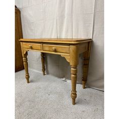 a wooden table with two drawers and one drawer on the top, in front of a white curtain