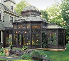 a gazebo in the middle of a yard next to a house