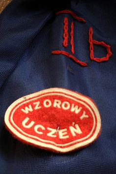 a red and white patch on a blue jacket with the word wzrowwy uczen