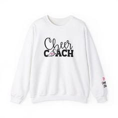 Personalized Cheer Coach Sweatshirt - Custom Name | Cheerleading Team Gift Celebrate your cheer coach with our personalized sweatshirt, designed to honor their dedication and leadership! Each sweatshirt is carefully customized with the coach's name, making it a heartfelt and unique gift for any occasion. PRODUCT DETAILS: -Materials: Made with a medium-heavy fabric blend of 50% cotton and 50% polyester (8.0 oz/yd² (271.25 g/m this sweatshirt feels cozy and is the perfect choice for those colder months. -Personalization: Customized with [Coach's Name] in a stylish font (Please specify the name in personalization box) Why Choose Our Sweatshirt? - Customized Just for You: Each sweatshirt is made-to-order with the coach's name, ensuring a personal touch. - Quality Materials: Crafted from a soft Sporty White Sweatshirt With Letter Embroidery, White Sporty Sweatshirt With Letter Embroidery, White Tops With Letter Embroidery For Sports Season, White Tops With Team Spirit Lettering, Sporty Tops With Letter Embroidery For Sports Events, Sporty White Tops With Letter Embroidery, Graphic Print Cotton Sweatshirt For Team Events, White Team Spirit Sweatshirt For Cheerleading, Team Spirit Tops With Letter Embroidery For Sports Events