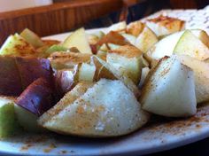 a white plate topped with sliced apples and cinnamon