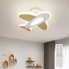 a child's bedroom with a white ceiling light and wooden shelves on the wall