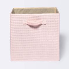 a pink storage bin with handles on the top and bottom, in front of a white background