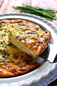 a quiche on a plate with a slice cut out