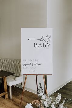 a welcome sign for a baby to be placed on an easel next to flowers