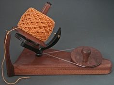 a wooden object with yarn on top of it