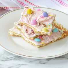 some kind of dessert on a plate with pink icing and candies all over it