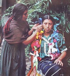 the woman is getting her hair combed by the lady in the native style dress