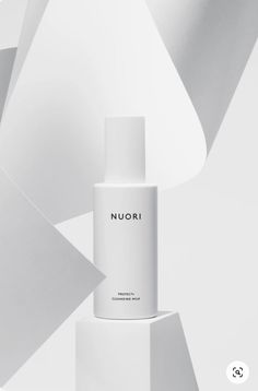 a white bottle with the word nuori on it sitting in front of an abstract background