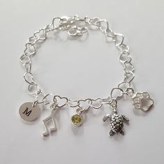 Personalized charm bracelet + Sterling silver heart (5.3 mm) bracelet with lobster clasp (can be adjusted upto 7 inch) + Sterling silver disk (9mm) + Sterling silver music note (10mm) + Sterling silver birthstone (5mm) + Sterling silver turtle charm (10mm) + Sterling silver paw print (8mm) * Every item comes in a pretty gift box * I can also make it with other charms in my shop, please contact me if you would like different designs Silver Music-themed Bracelets For Gifts, Music-themed Silver Bracelet As A Gift, Silver Music-themed Bracelet As Gift, Silver Music-themed Bracelet For Gift, Customized Adjustable Silver Charm Bracelet, Adjustable Sterling Silver Charm Bracelet For Birthday, Adjustable Sterling Silver Charm Bracelet For Birthday Gift, Sterling Silver Charm Bracelet, Turtle Charm