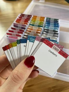 a person holding some cards in their hand with color swatches on top of them