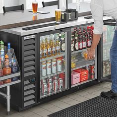 a man standing in front of a cooler filled with drinks