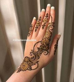 a woman's hand with henna tattoos on it