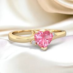 Delicate and dainty, this 14K Gold ring is a lovely way to express the love within you. A heart shaped vibrant pink lab pink sapphire is the focus of this ring, with two sparkling diamonds. It creates an elegant look that is not overstated, and is beautiful on the hand. It is perfect as an everyday ring and an excellent choice for a promise ring as well.  Gem: Lab Created Pink Sapphire Metal: solid 14K Gold Diamonds: genuine SI2 diamonds Free gift packaging is included with every order. Pink Sapphire Heart Ring, Heart-shaped Pink Sapphire Wedding Jewelry, Pink Heart-shaped Rings With Diamond Accents, Pink Sapphire Heart Cut Jewelry, Elegant Heart-shaped Pink Sapphire Jewelry, Diamond Free, Everyday Rings, 14k Gold Ring, Multi Stone Ring