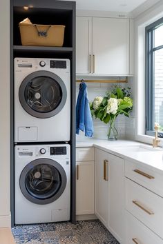 a washer and dryer in a kitchen next to a window with flowers on it