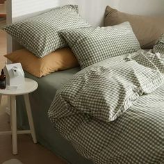 an unmade bed with two pillows and a bottle of beer on the side table