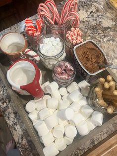 there are many different types of candies on the counter top, including marshmallows and chocolate