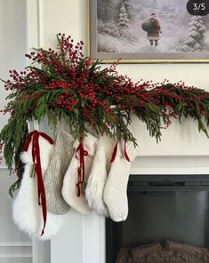 stockings hanging from a mantel decorated with red berries and greenery