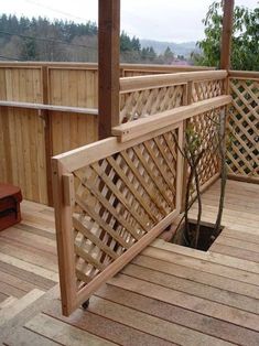 a wooden deck with an umbrella over it and a tree growing in the hole below