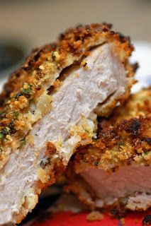 two pieces of meat sitting on top of a red and white plate with crumbs