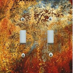 two light switch plates on an old rusted metal surface