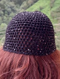 a woman with red hair wearing a black crochet headband on top of her head