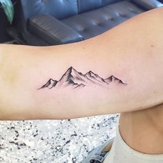 a woman with a mountain tattoo on her arm