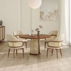 a dining room table with four chairs and a vase on the table in front of it