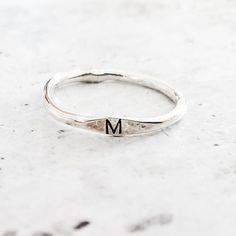 This dainty and charming ring is hand-crafted from high-quality sterling silver, ensuring both durability and style. Choose your favorite initial to be hand stamped on the ring, making it a delightful and meaningful gift for yourself or someone special. With meticulous precision, we create a unique design that adds a playful flair to the ring's overall allure. Express your individuality and show off your style by stacking this fabulous Sterling Silver Initial Ring with other favorites. Whether y Meaningful Silver Stackable Rings Gift, Personalized Silver Stackable Rings As Gift, Silver Stackable Rings For Gift, Meaningful Style, Minimalist Stackable Rings For Gifts, Minimalist Stackable Rings For Gift, Adjustable Stackable Rings With Initials, Dainty Adjustable Stackable Initials Rings, Dainty Adjustable Stackable Rings With Initials, Everyday Engraved Initials Open Ring