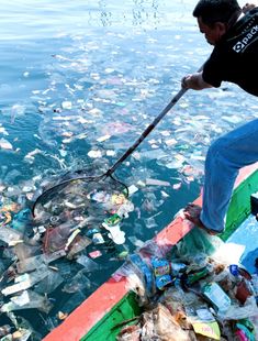 a man on a boat in the ocean surrounded by trash