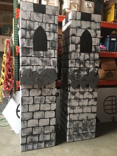 two cardboard castles made to look like they are standing in the middle of a warehouse